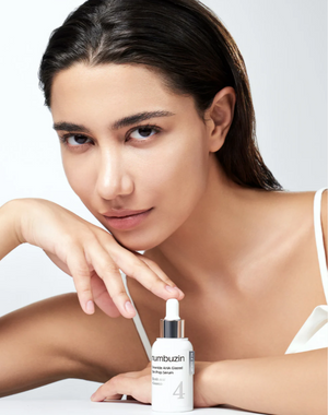 YABUKO Numbuzin No.4 Ceramide AHA serums ar keramikīdiem un AHA, mirdzošai ādas kopšanai, uz seruma pudeles ar baltu šķidru tekstūru.